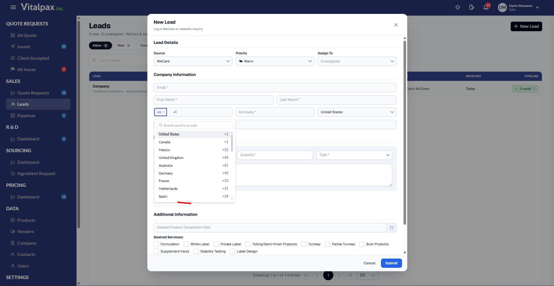 The New Lead dialog on the Leads page, subtitled 'Log a WeCare or website inquiry'. Lead Details shows Source WeCare, Priority Warm and Assign To Unassigned. Under Company Information the phone row is open on the new country-prefix picker, underlined in red: a '+1' dropdown button sits beside a phone field pre-filled with '+1', and the open panel has a 'Search country or code' box above a scrollable list - United States +1, Canada +1, Mexico +52, United Kingdom +44, Australia +61, Germany +49, France +33, Netherlands +31, Spain +34. The country select to the right reads United States. Additional Information below carries a Desired Product Completion Date field and Desired Services checkboxes (Formulation, White Label, Private Label, Tolling/Semi-finish Products, Turnkey, Partial Turnkey, Bulk Products, Supplement Facts, Stability Testing, Label Design), with Cancel and Submit in the footer.